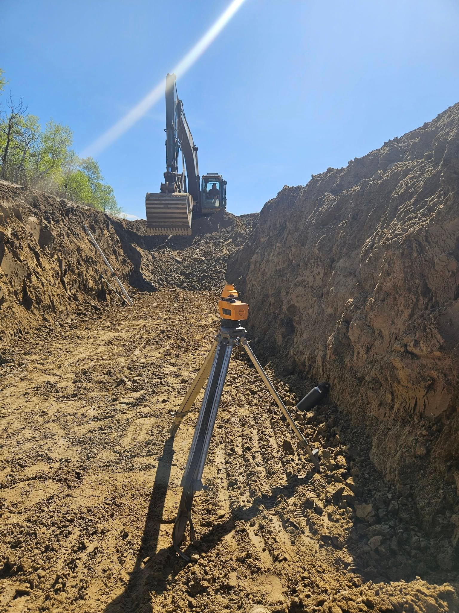 Excavator clearing and grading a construction site